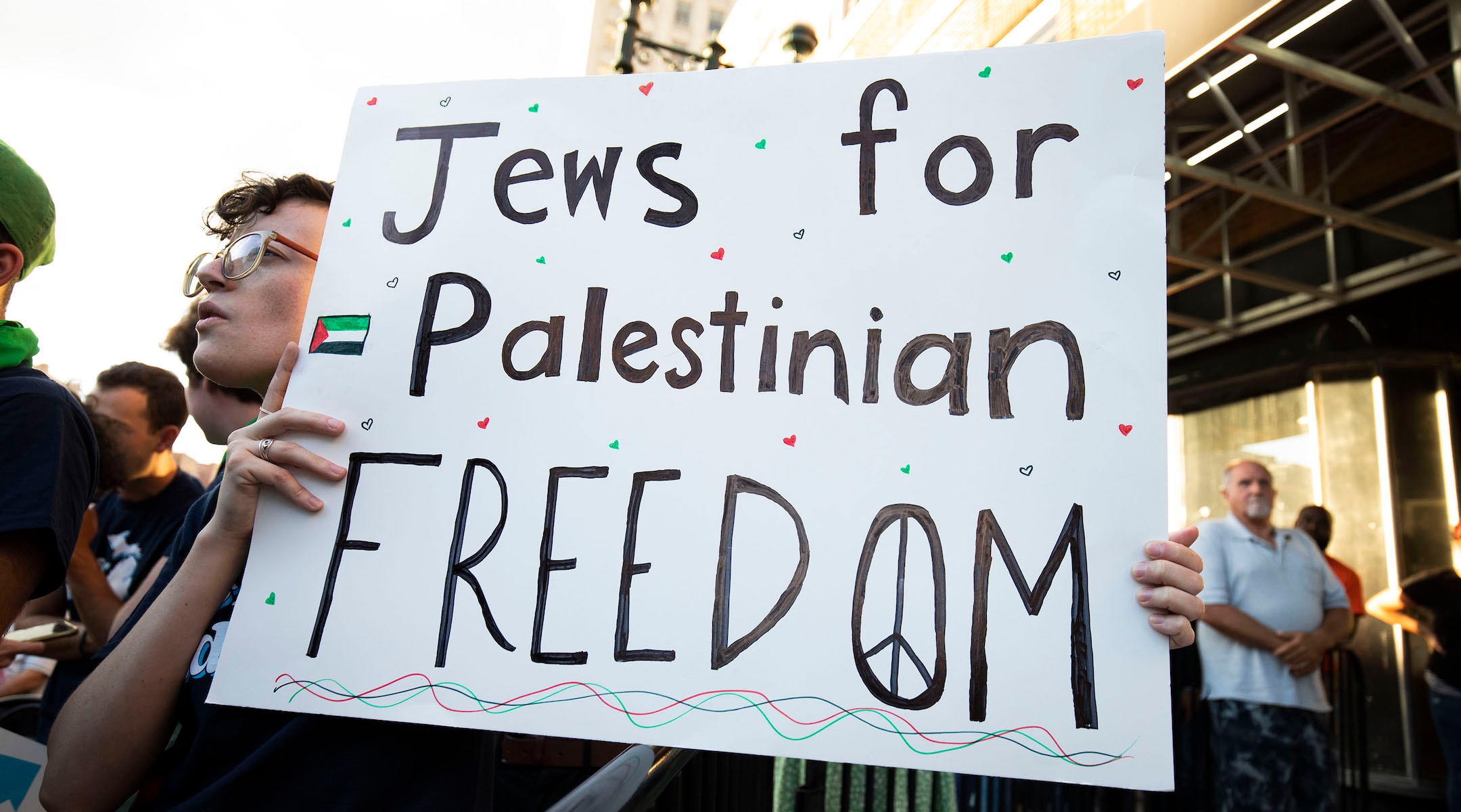 An attendee at a campaign rally holding a sign reading 