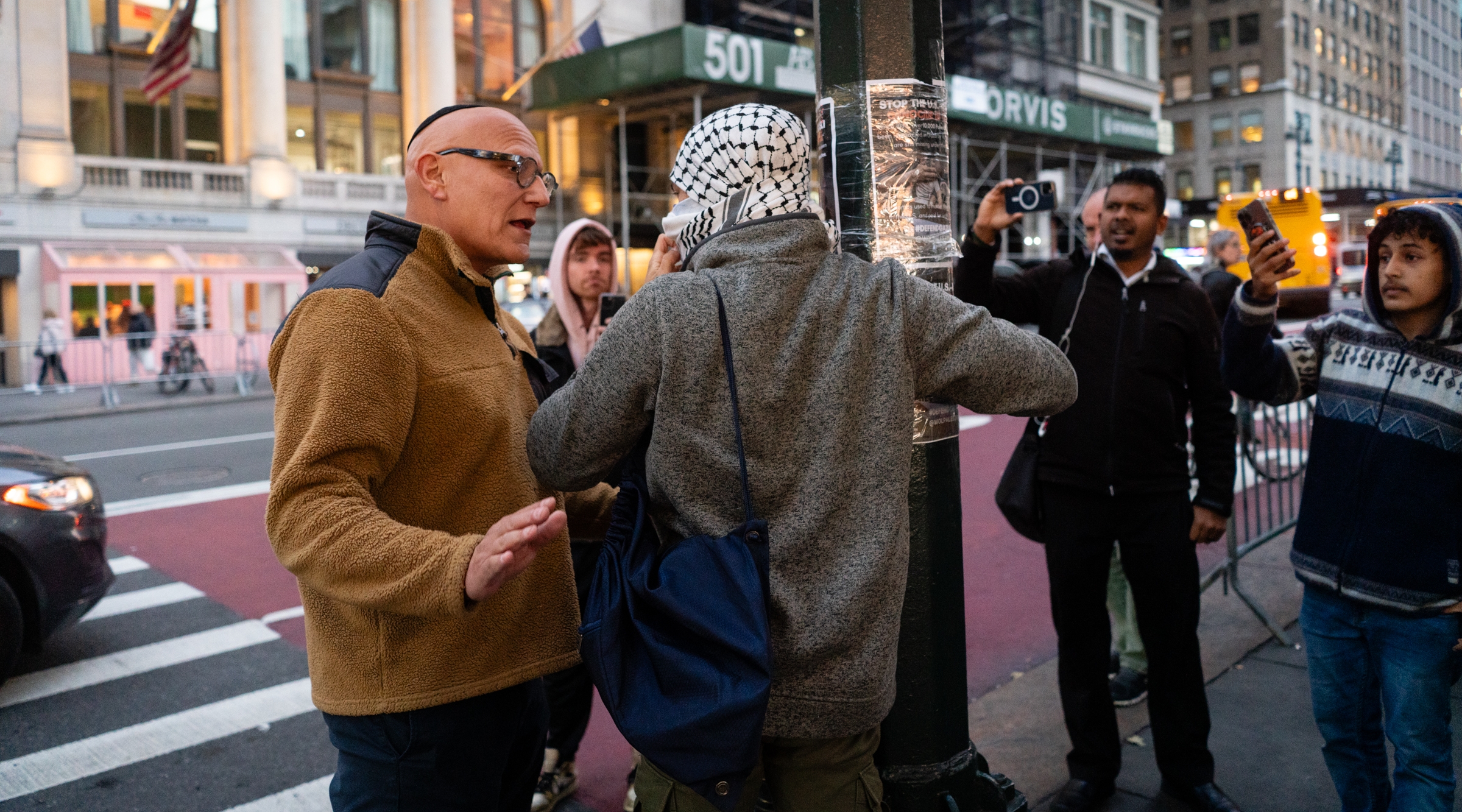 A Jewish man and an anti-Israel activist argue about street posters in midtown Manhattan, Nov. 9, 2023. (Luke Tress)