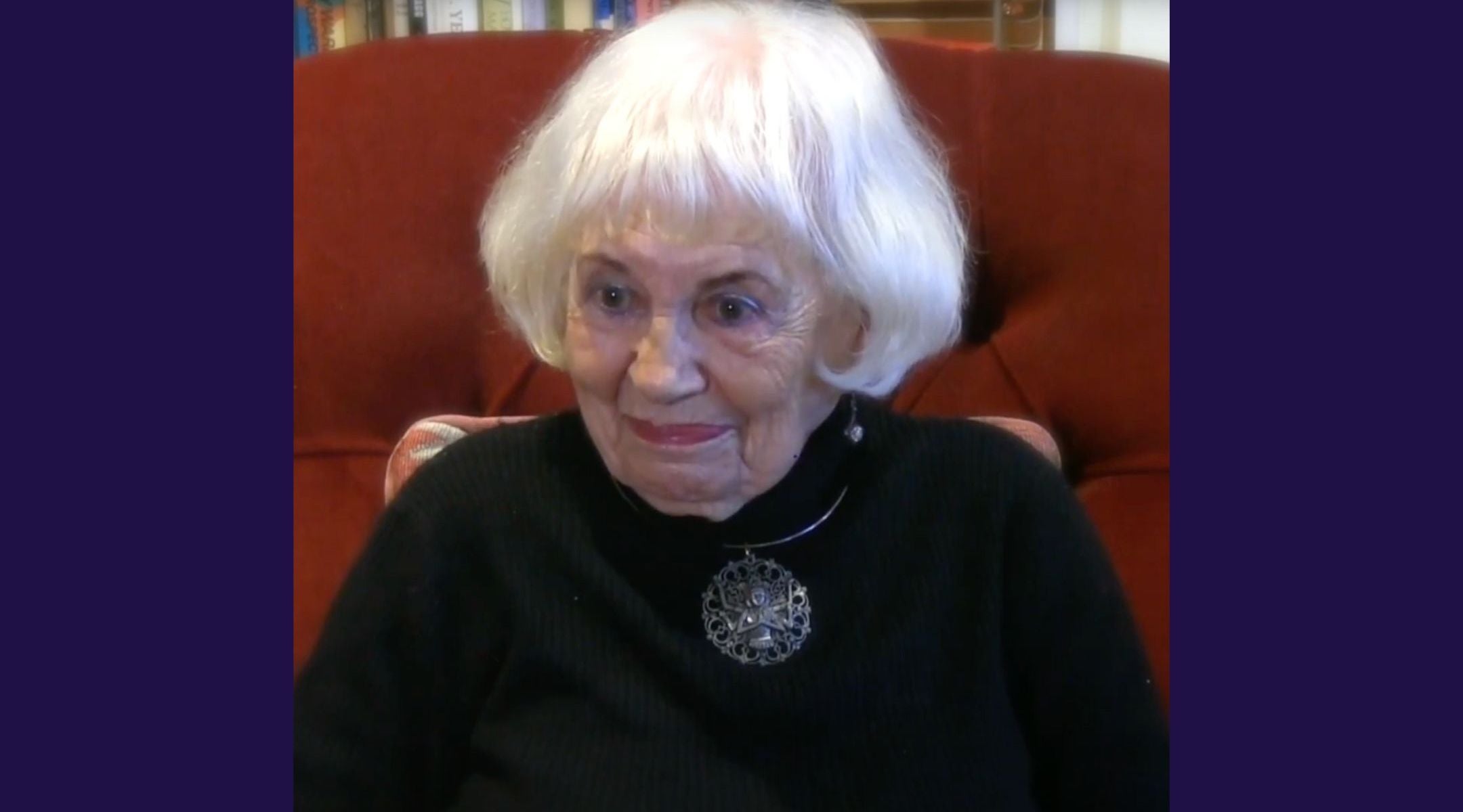 A photo of Posner smiling while seated on a couch.