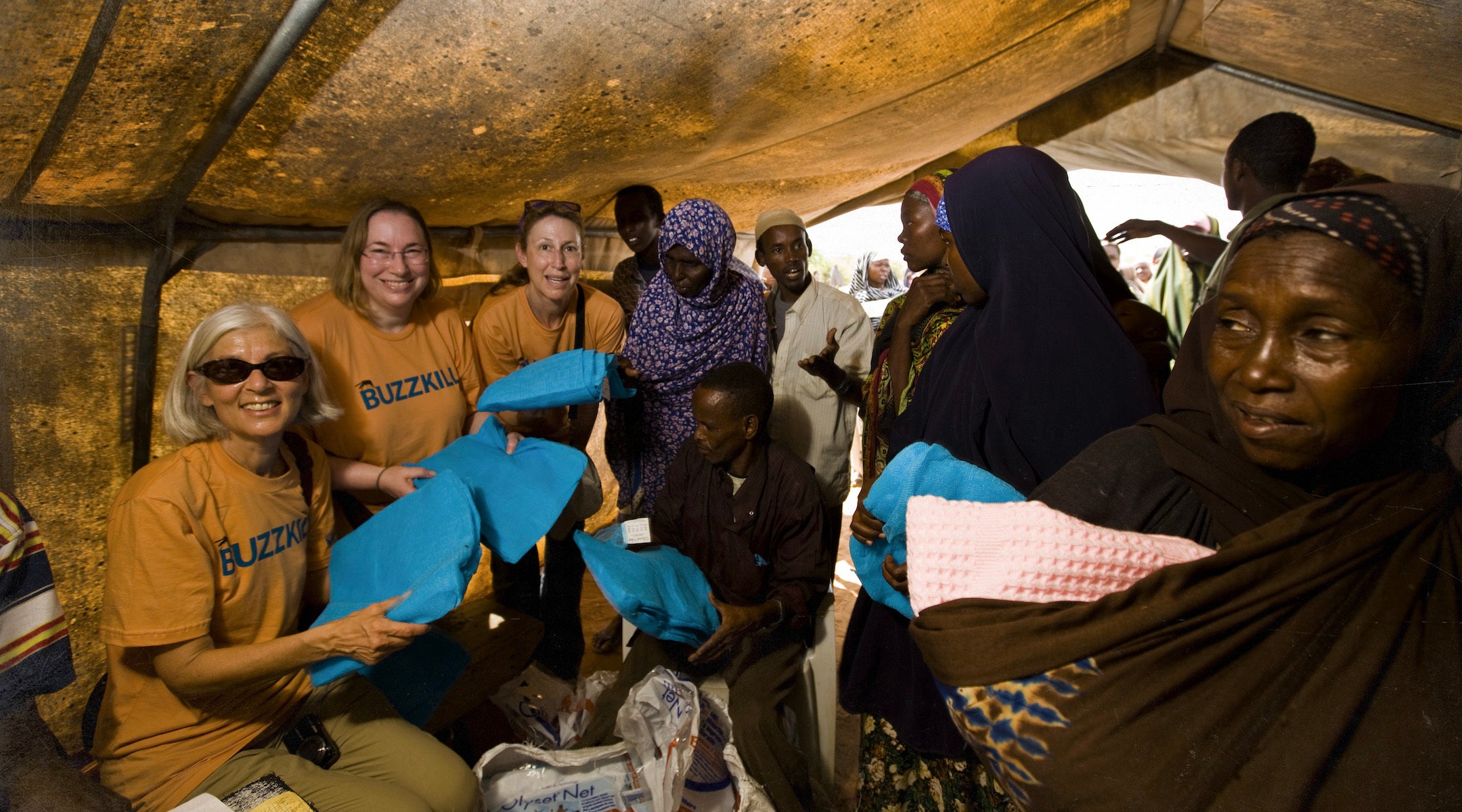Jewish women pose with Sudanese refugees in a tent