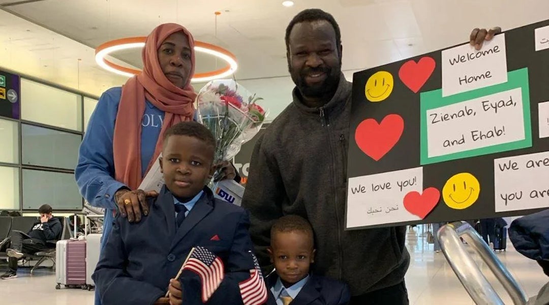 A smiling Sudanese family reunites in an American airport