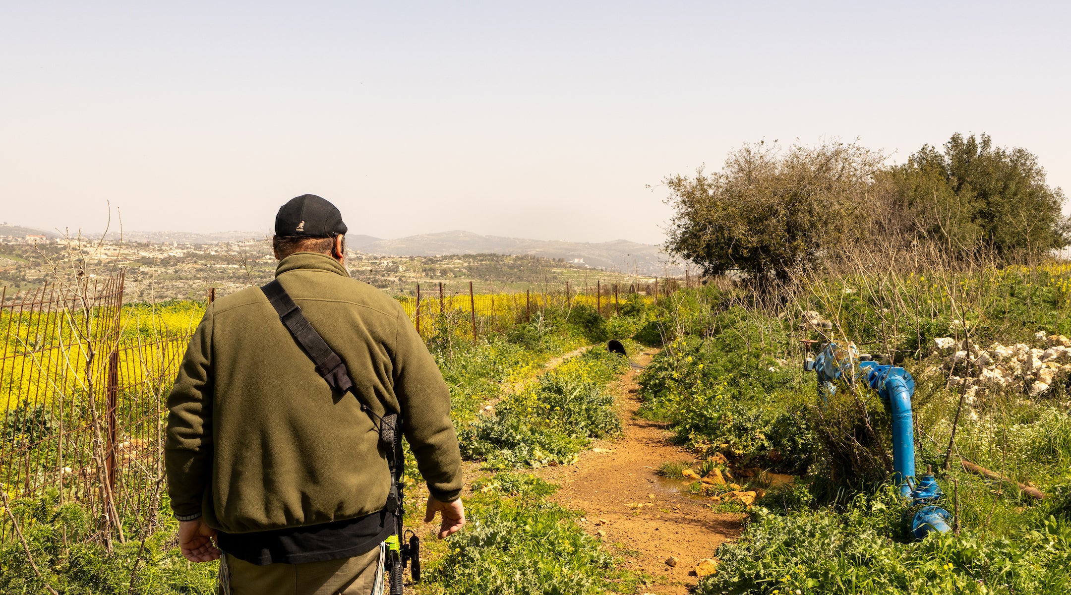 A photo of a man walking down a dirt path.